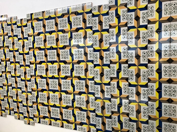 Le mur d’Azulejos Desordem évoque le dessin de la propagation des ondes sismiques à la manière des diagrammes géologiques. Exposition Colère divine